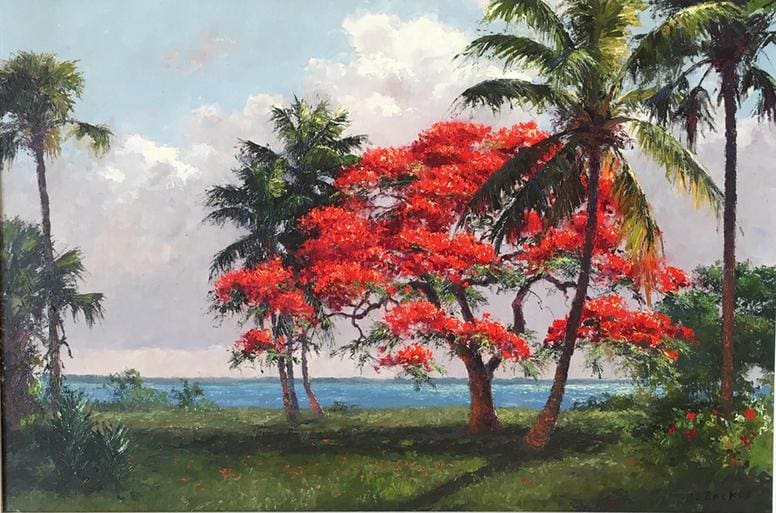 A vibrant red-flowered tree stands near the ocean, surrounded by palm trees and greenery, under a partly cloudy sky.